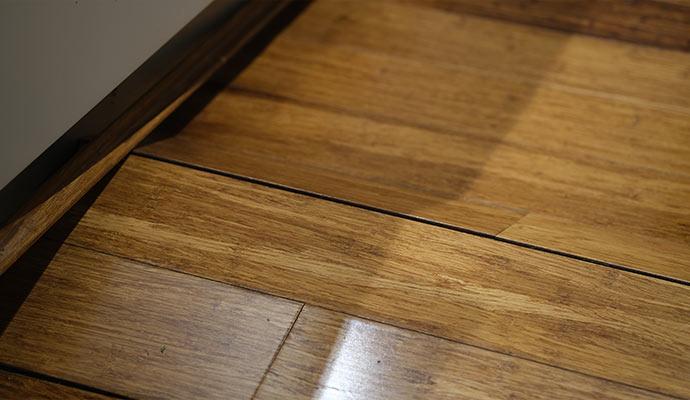 A close-up view of wooden floor planks buckling