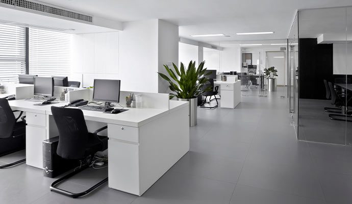 A modern office interior featuring white workstations