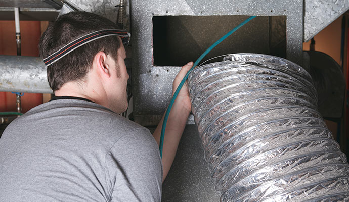 A professional installing flexible HVAC vent hose after cleaning