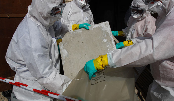Professional team with hazmat suit removing asbestos