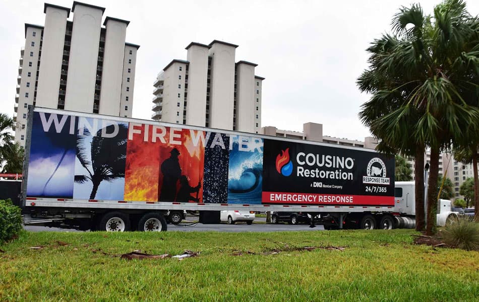 A large Cousino Restoration & Environmental service truck on road