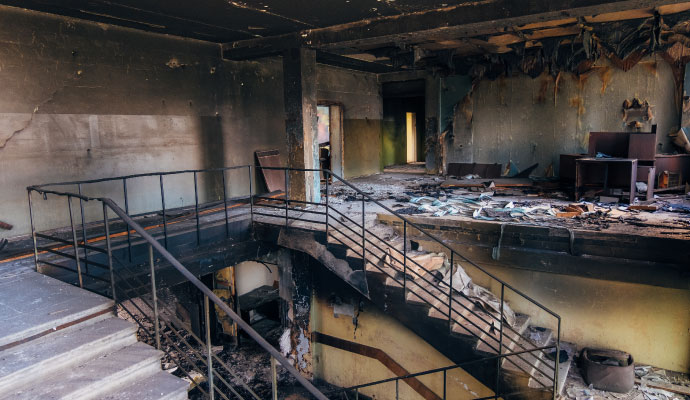 Charred building interior with staircase and fire debris