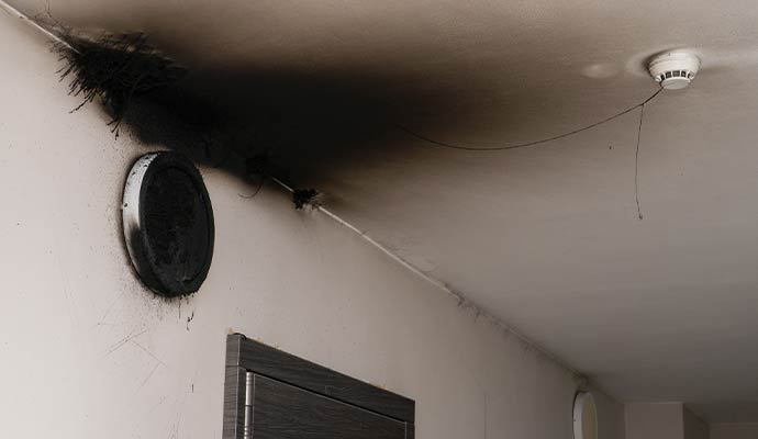 Fire and smoke damage on an interior ceiling and wall.