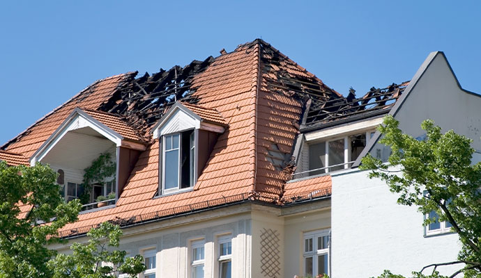 Fire damaged tiled roof with charred exposed rafters