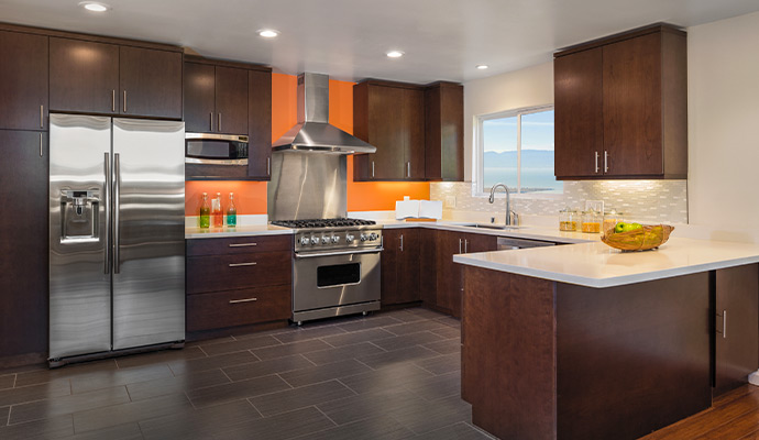 Modern kitchen with orange accent wall and stainless appliances