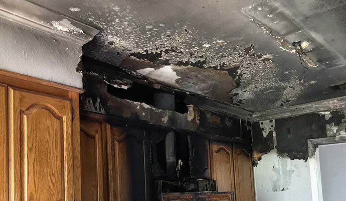 Burned kitchen ceiling and charred cabinets 
