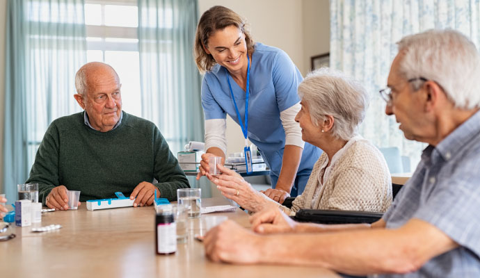 Nurse hands out medication to elderly residents in a care center
