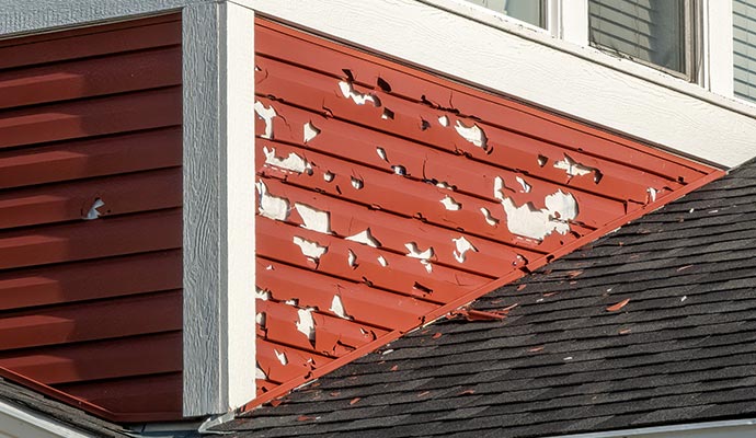 Severe hail damage on house siding and roof.