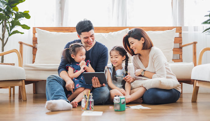 A happy family sitting together on a living room floor