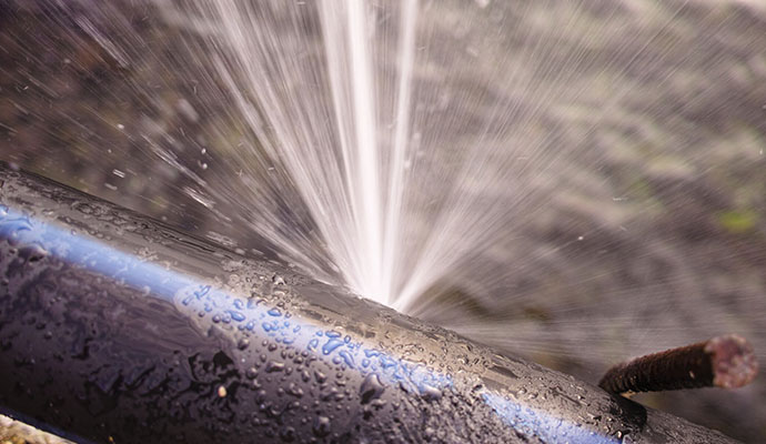 A metal burst pipe leaking water