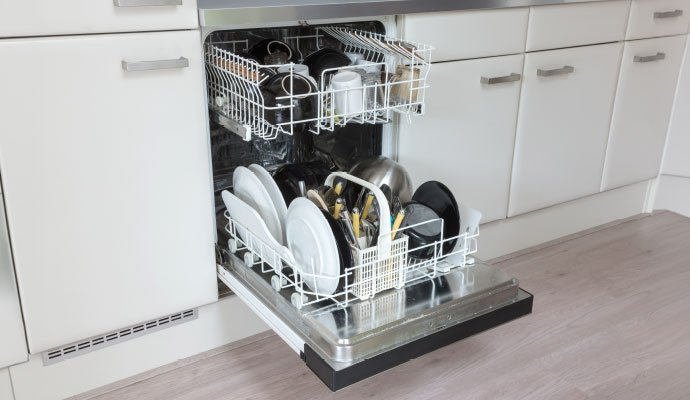 Open dishwasher loaded with dishes in the kitchen