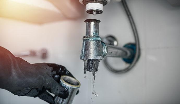 Plumber clearing a clogged drain blockage pipe
