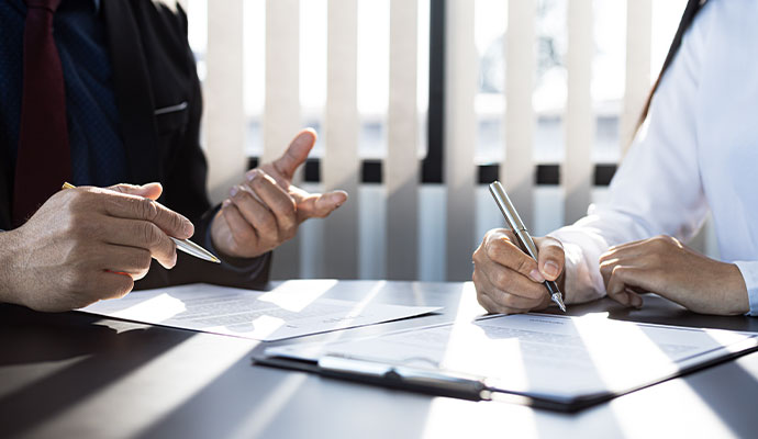 Professionals signing insurance claim documents.