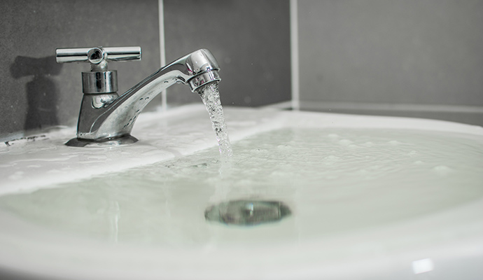 Bathroom sink overflowing with water