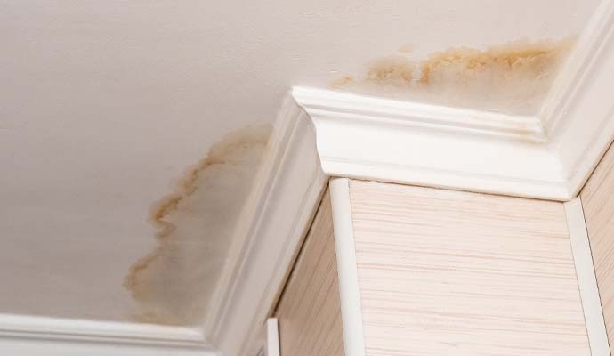 Water stain damage on a ceiling caused by a roof leak